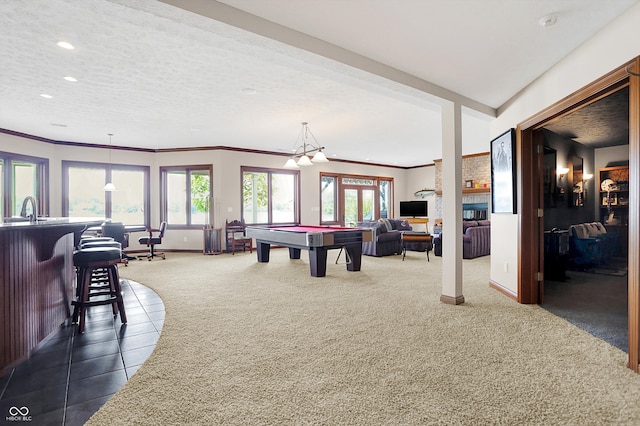 recreation room with a textured ceiling, dark colored carpet, and billiards