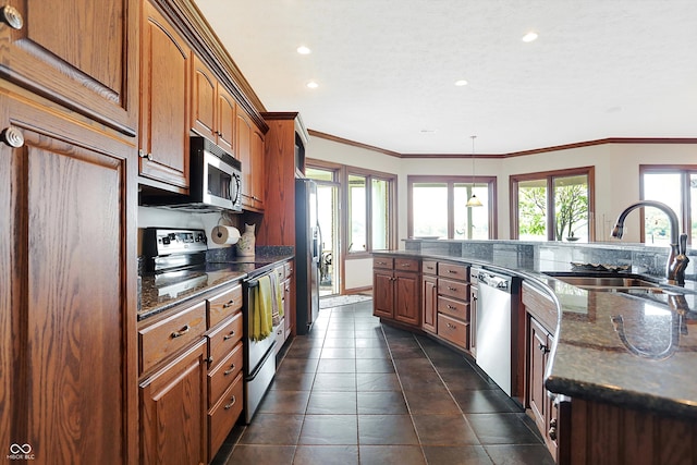 kitchen with hanging light fixtures, stainless steel appliances, plenty of natural light, and sink