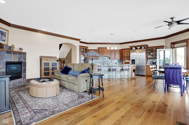 living room featuring light hardwood / wood-style flooring, ceiling fan, and crown molding