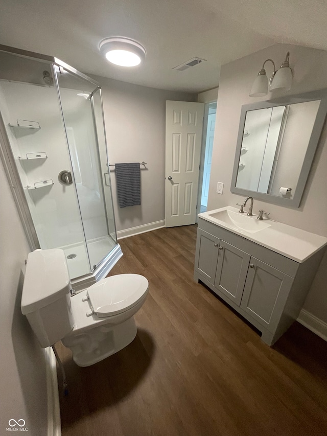 bathroom with vanity, toilet, a shower with door, and hardwood / wood-style flooring