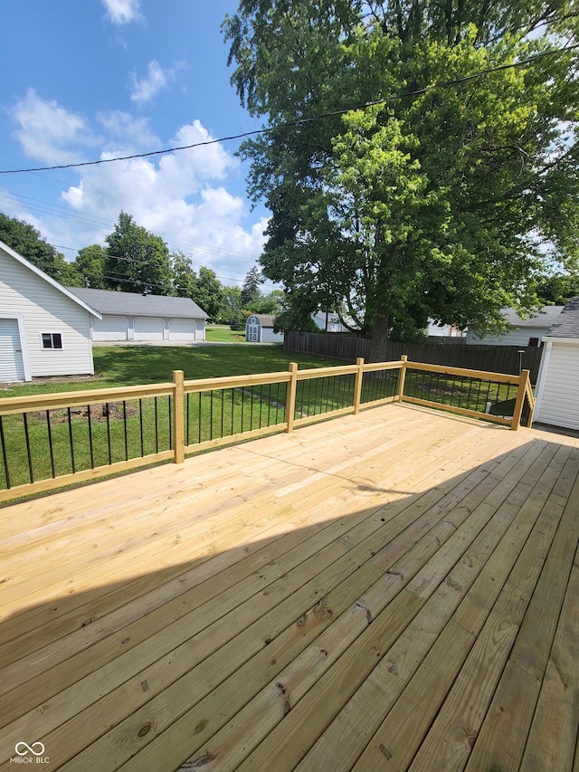 wooden deck with an outbuilding and a lawn