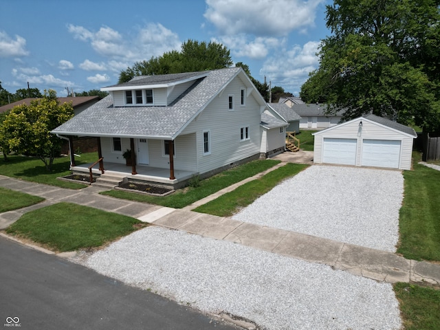 view of front of property featuring a porch, a garage, a front lawn, and an outdoor structure