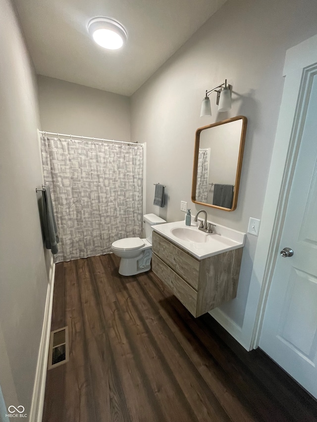 bathroom featuring vanity, wood-type flooring, and toilet