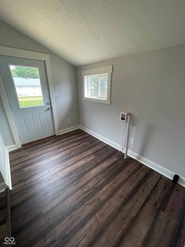 foyer entrance featuring a textured ceiling, hardwood / wood-style flooring, and lofted ceiling