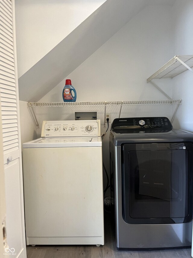 laundry area with hardwood / wood-style flooring and washer and dryer