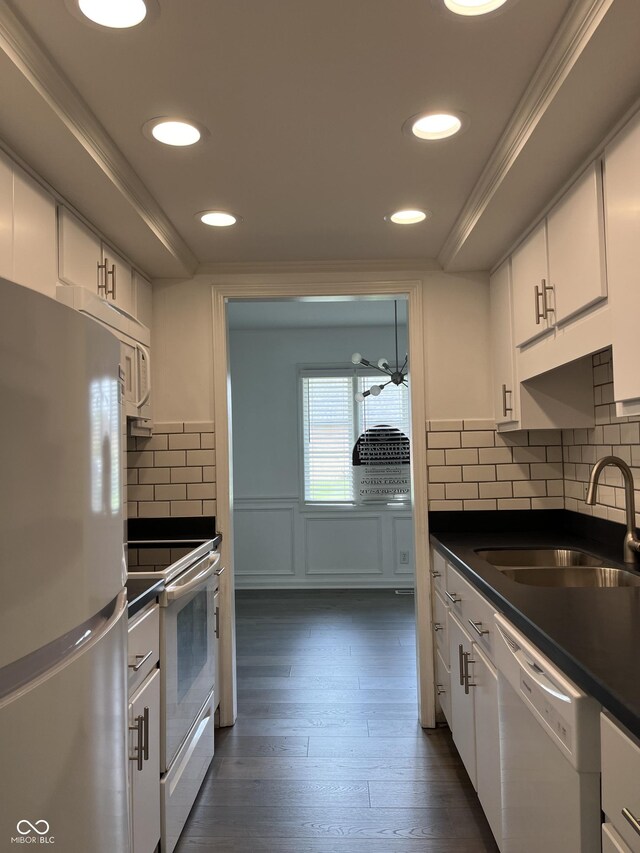 kitchen with sink, dark hardwood / wood-style flooring, white appliances, and backsplash