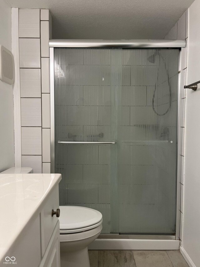 bathroom with vanity, toilet, tile patterned flooring, and an enclosed shower