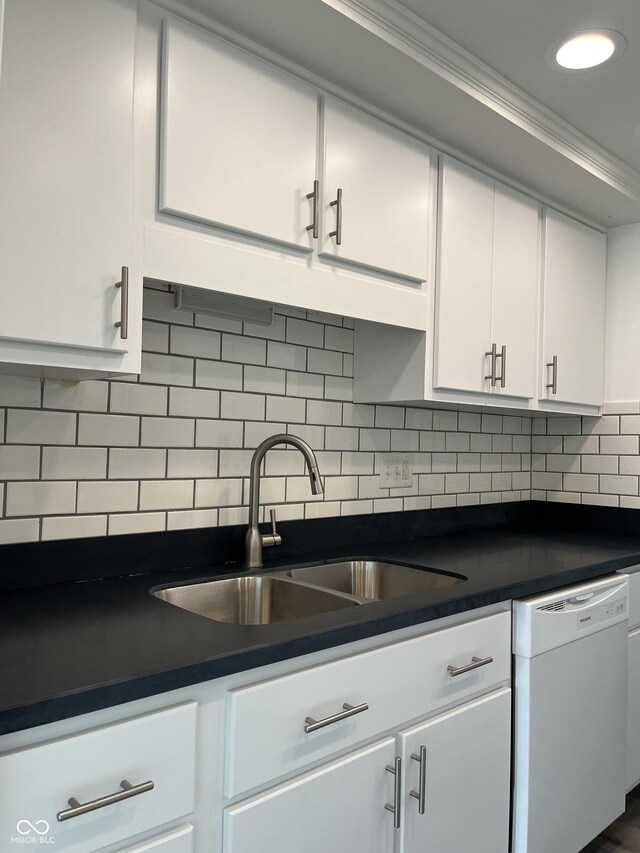 kitchen featuring sink, white cabinetry, white dishwasher, and decorative backsplash