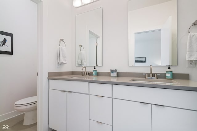 bathroom featuring double vanity and toilet