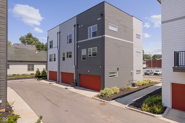 exterior space with a garage and central AC