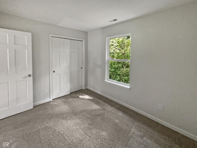 unfurnished bedroom with a closet and carpet flooring