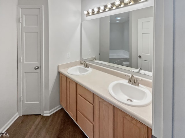 bathroom with vanity, a tub to relax in, and wood-type flooring