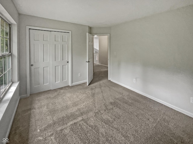 unfurnished bedroom with a closet and carpet