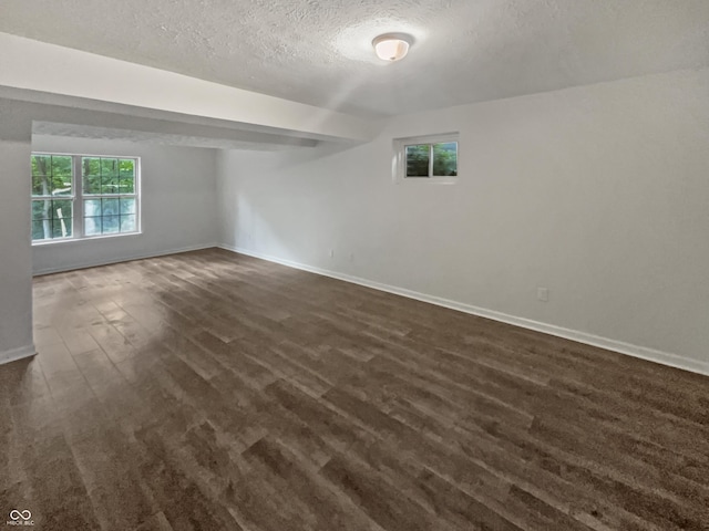 spare room with a textured ceiling and dark hardwood / wood-style flooring