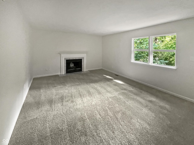 unfurnished living room featuring a fireplace and carpet flooring