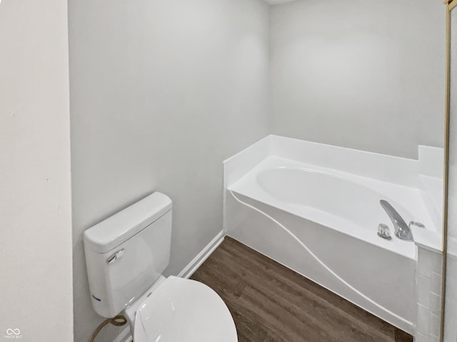 bathroom featuring a bath, wood-type flooring, and toilet