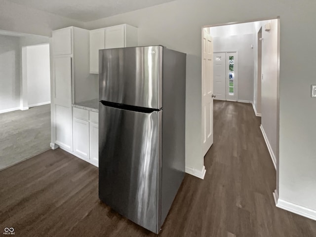 kitchen with stainless steel fridge, dark hardwood / wood-style floors, and white cabinets