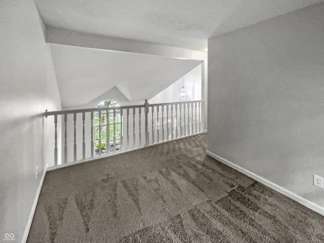 carpeted spare room featuring lofted ceiling