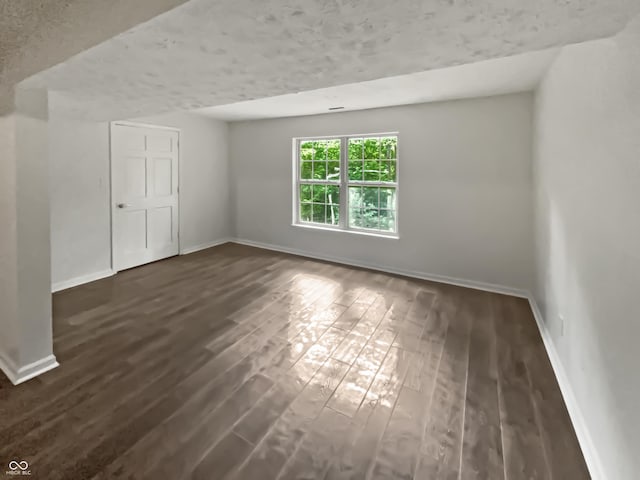 empty room with dark hardwood / wood-style flooring