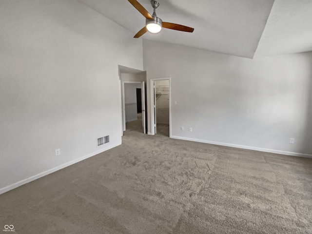 carpeted spare room featuring high vaulted ceiling and ceiling fan