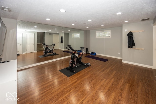 workout room with hardwood / wood-style flooring and a textured ceiling