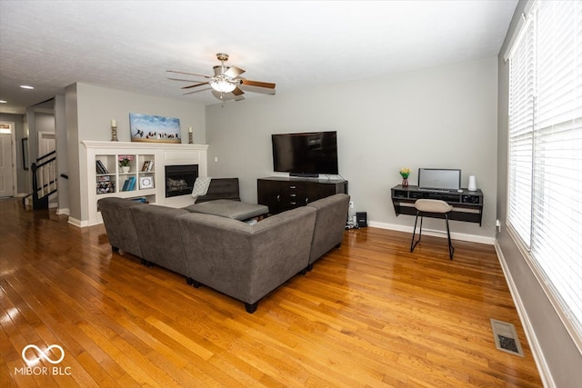 living room with light wood-type flooring and ceiling fan