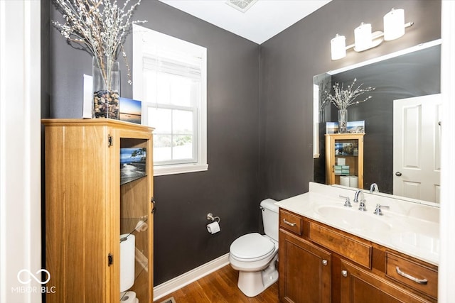 bathroom with hardwood / wood-style floors, vanity, and toilet