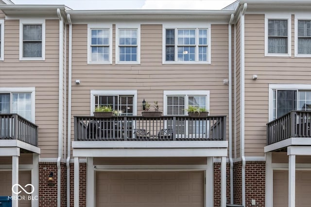 rear view of house with a balcony and a garage