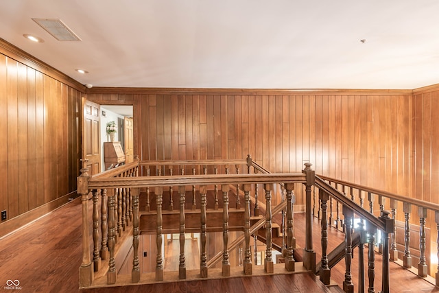 corridor with wooden walls and hardwood / wood-style flooring