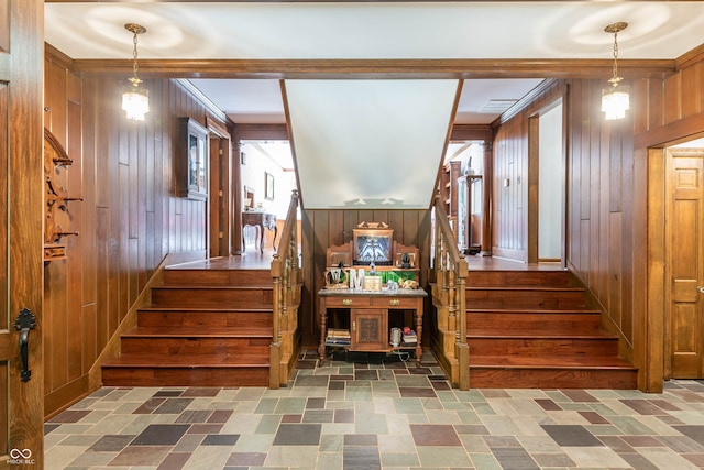 stairway featuring wood walls and dark tile patterned flooring