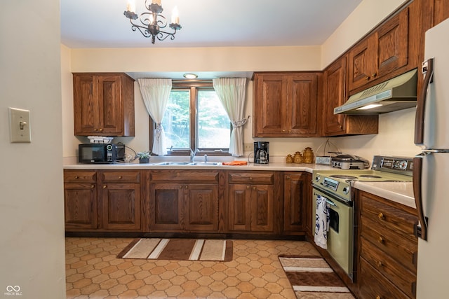 kitchen featuring light tile patterned flooring, a chandelier, fridge, and white stove