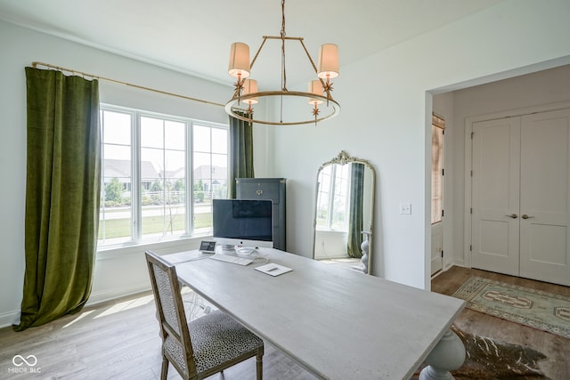 office space featuring a wealth of natural light, an inviting chandelier, and light hardwood / wood-style floors