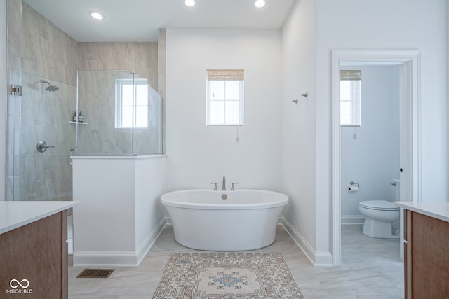 bathroom with vanity, a tile shower, toilet, and tile patterned floors