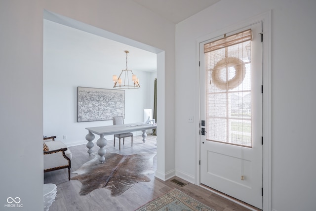 entrance foyer with an inviting chandelier and hardwood / wood-style flooring