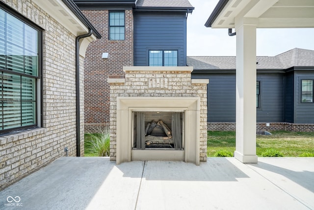 entrance to property featuring exterior fireplace and a patio area