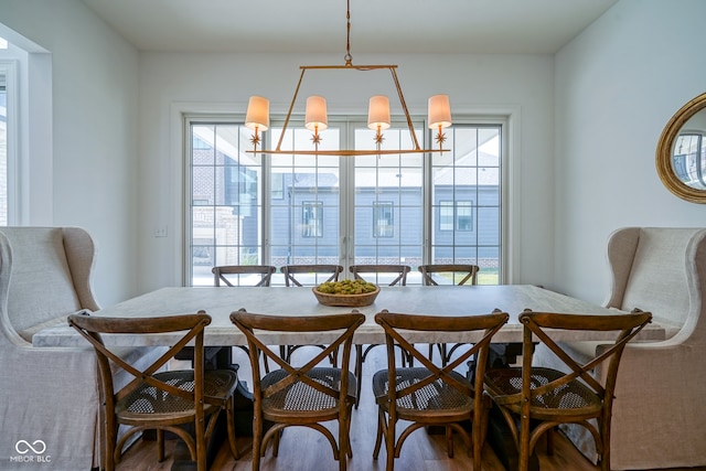 dining area featuring wood-type flooring and a notable chandelier