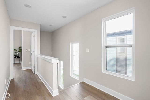 corridor with hardwood / wood-style flooring and a wealth of natural light