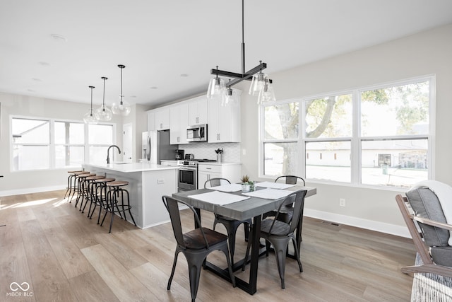 dining space featuring sink and light hardwood / wood-style floors