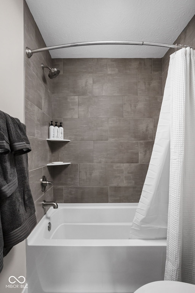 bathroom featuring shower / tub combo, toilet, and a textured ceiling