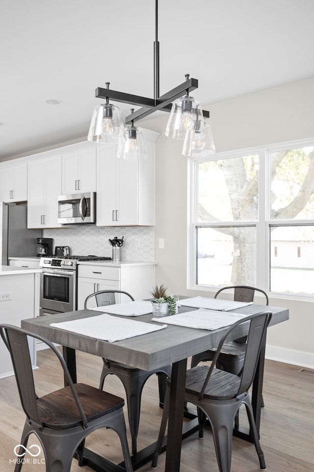 dining area with a healthy amount of sunlight and light hardwood / wood-style flooring