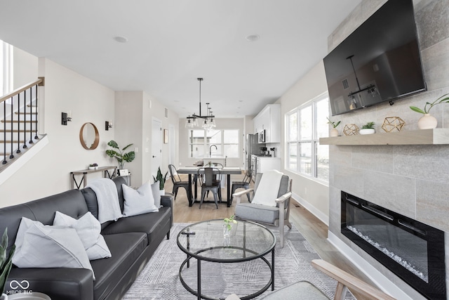 living room with light hardwood / wood-style flooring and a tile fireplace