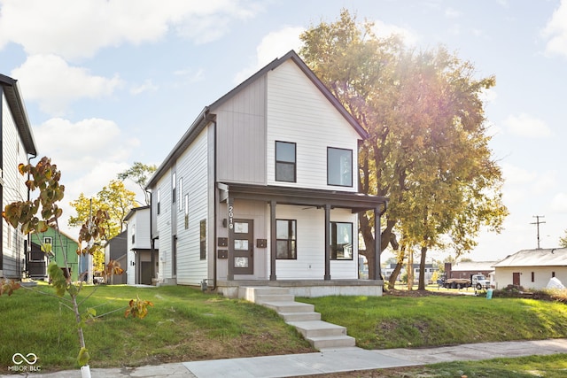 view of front of house with covered porch and a front lawn