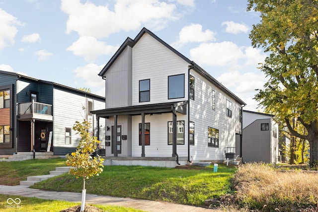 view of front facade with a balcony and a front lawn