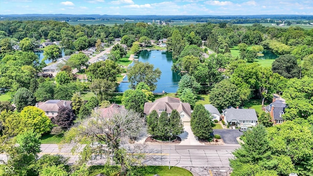 drone / aerial view with a water view, a wooded view, and a residential view
