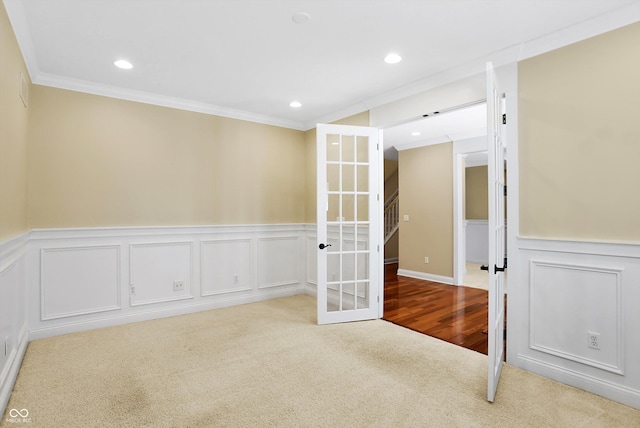 carpeted spare room featuring a wainscoted wall, crown molding, and recessed lighting