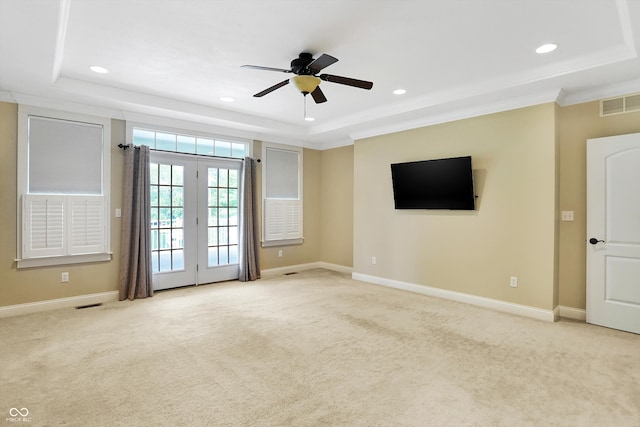 interior space featuring ceiling fan, light colored carpet, a raised ceiling, and french doors