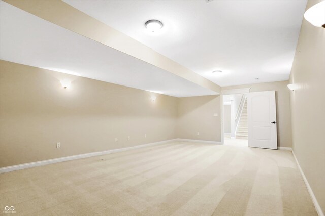 finished basement with baseboards and light carpet