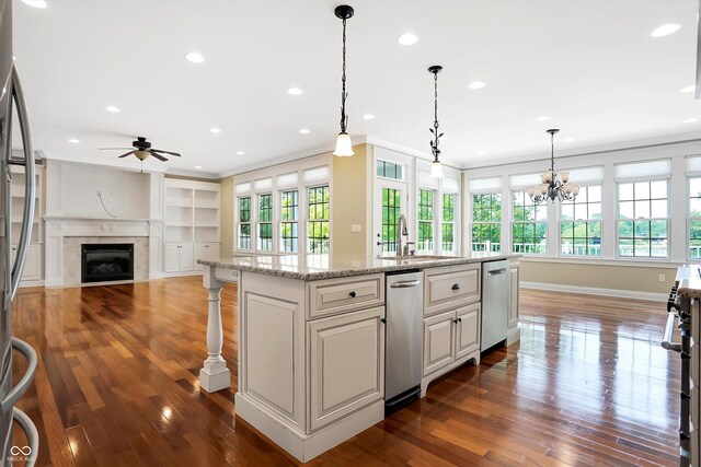 kitchen featuring a center island with sink, ceiling fan with notable chandelier, sink, and plenty of natural light