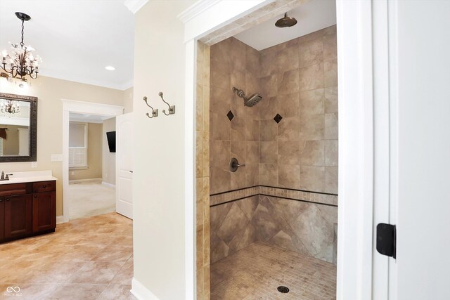 full bath with tiled shower, ornamental molding, vanity, and an inviting chandelier