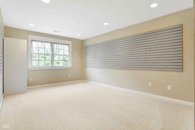 carpeted empty room with baseboards, visible vents, and recessed lighting